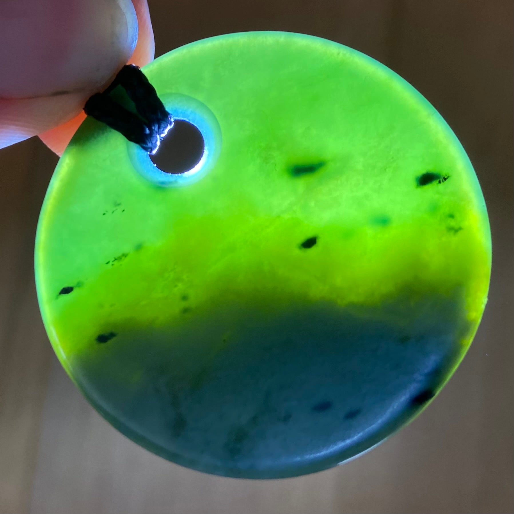Pounamu porohita, disc, circle of life pendant from New Zealand Kawakawa pounamu (greenstone). Translucency.