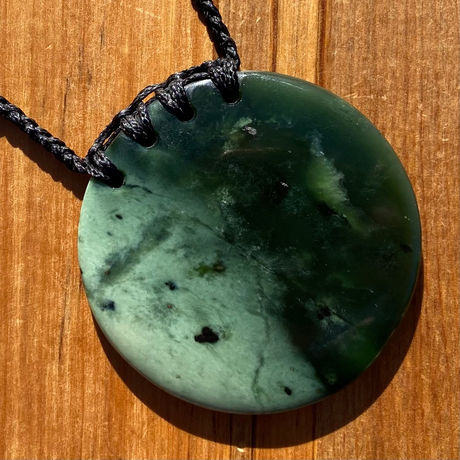 Pounamu porohita, disc, circle of life pendant from New Zealand Kawakawa pounamu (greenstone). Front.