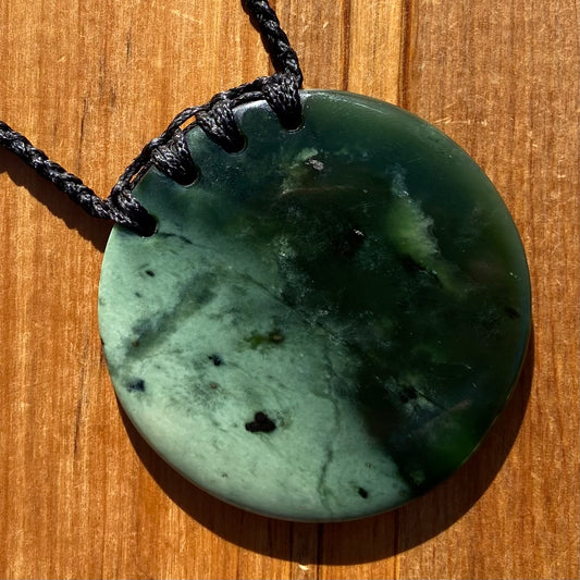 Pounamu porohita, disc, circle of life pendant from New Zealand Kawakawa pounamu (greenstone). Front.