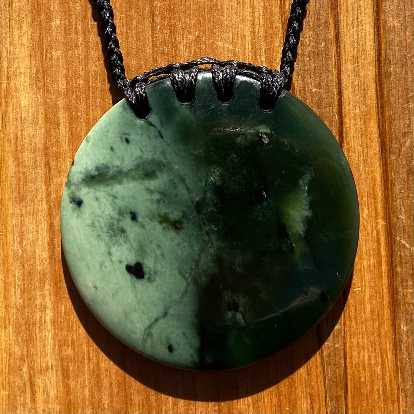 Pounamu porohita, disc, circle of life pendant from New Zealand Kawakawa pounamu (greenstone). Front.