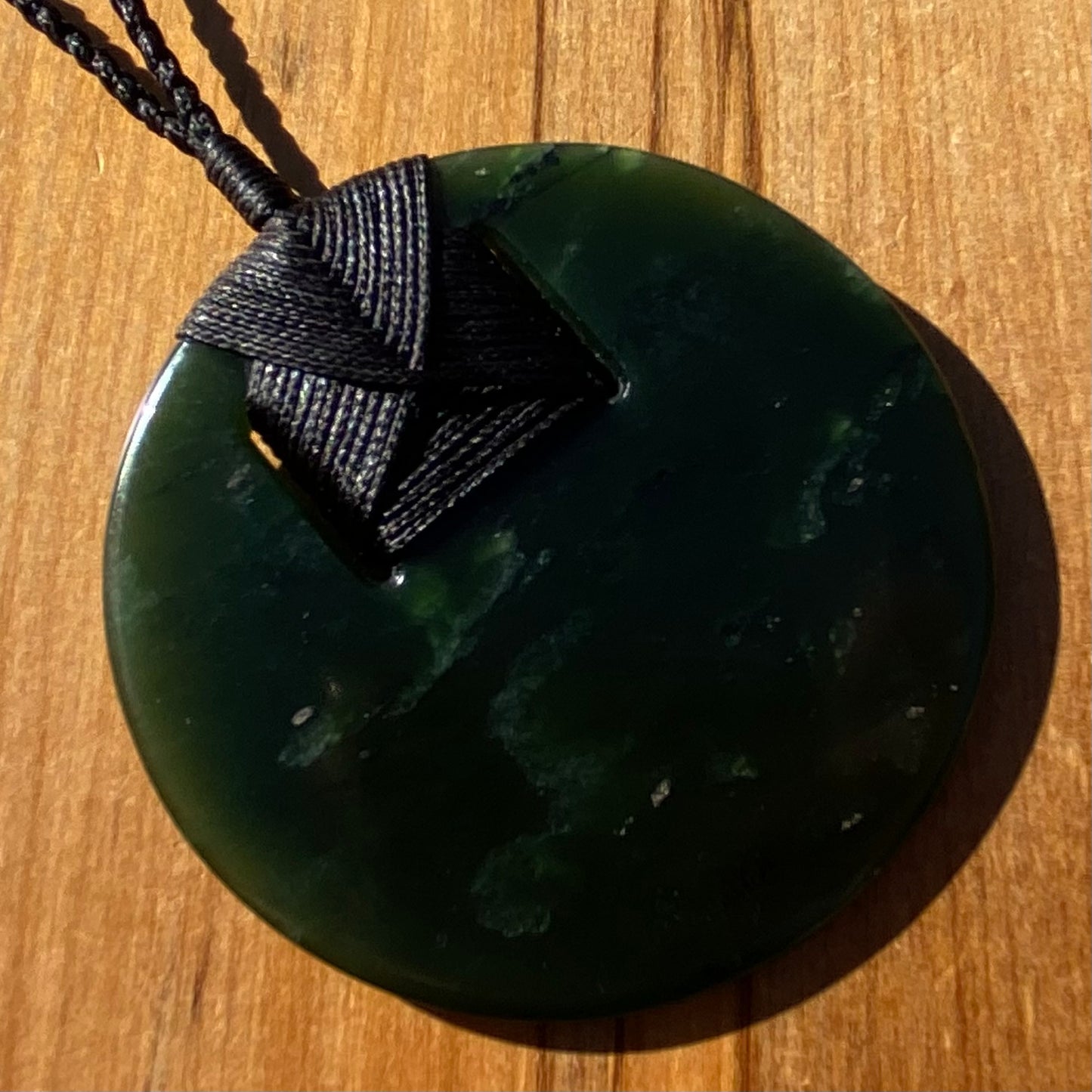 Pounamu porohita, disc, circle of life pendant from New Zealand Kawakawa pounamu (greenstone). Front.