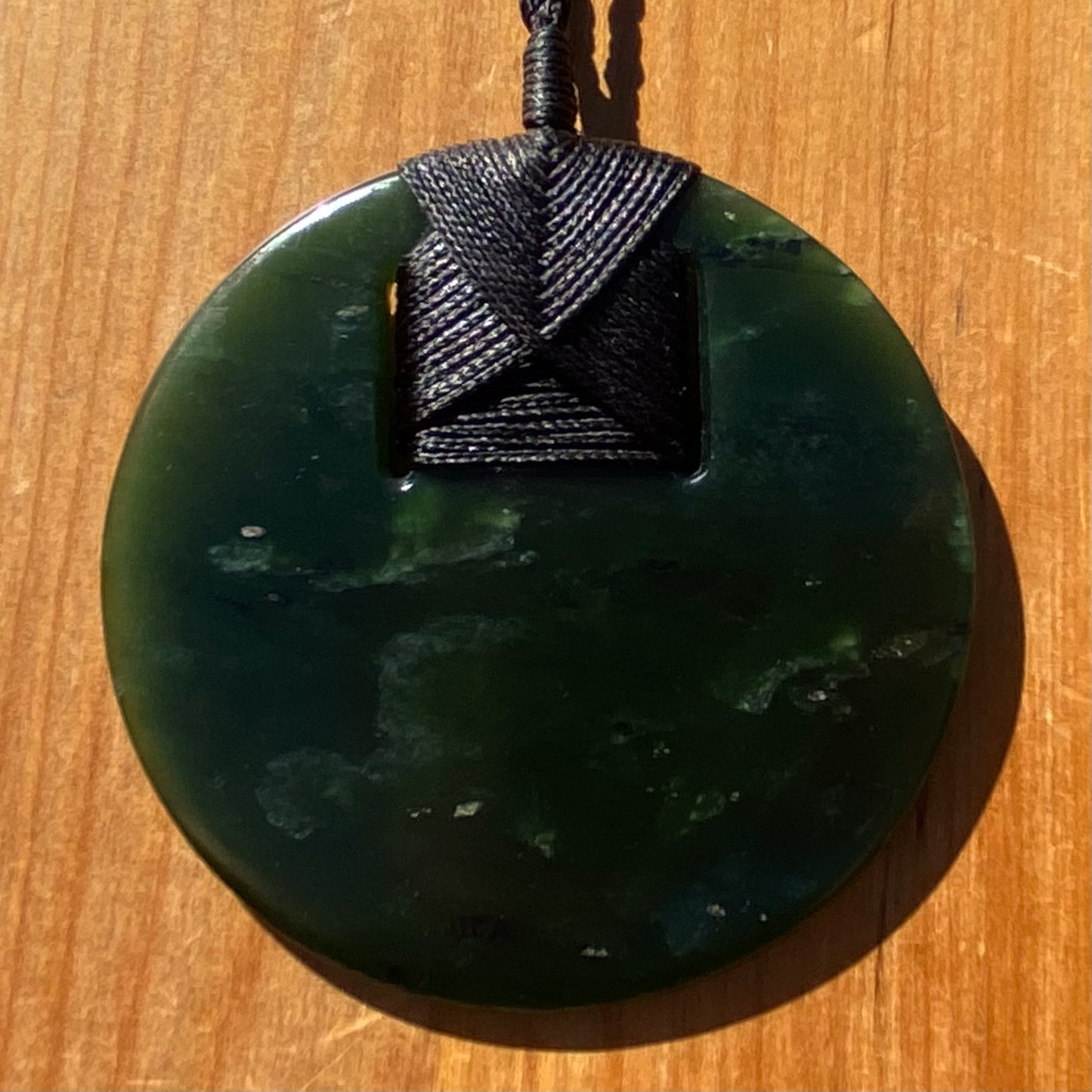 Pounamu porohita, disc, circle of life pendant from New Zealand Kawakawa pounamu (greenstone). Front.