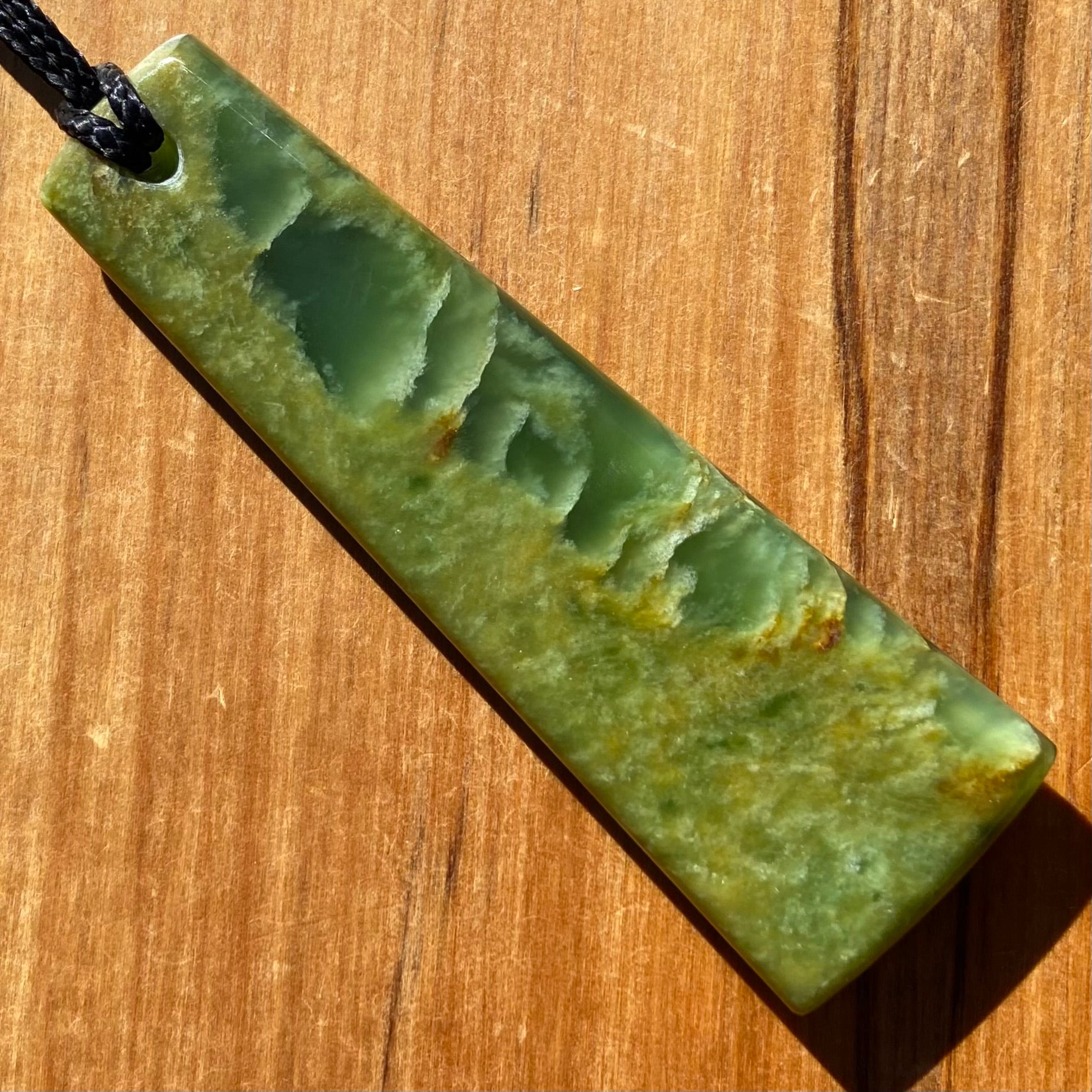 Pounamu toki pendant hand-carved from New Zealand Marsden Flower Jade pounamu (greenstone). Back.