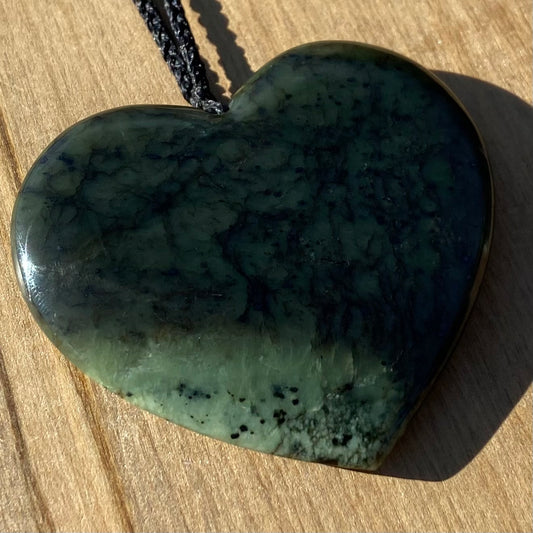 Heart pendant hand-carved from New Zealand kawawkawa pounamu (greenstone). Front.