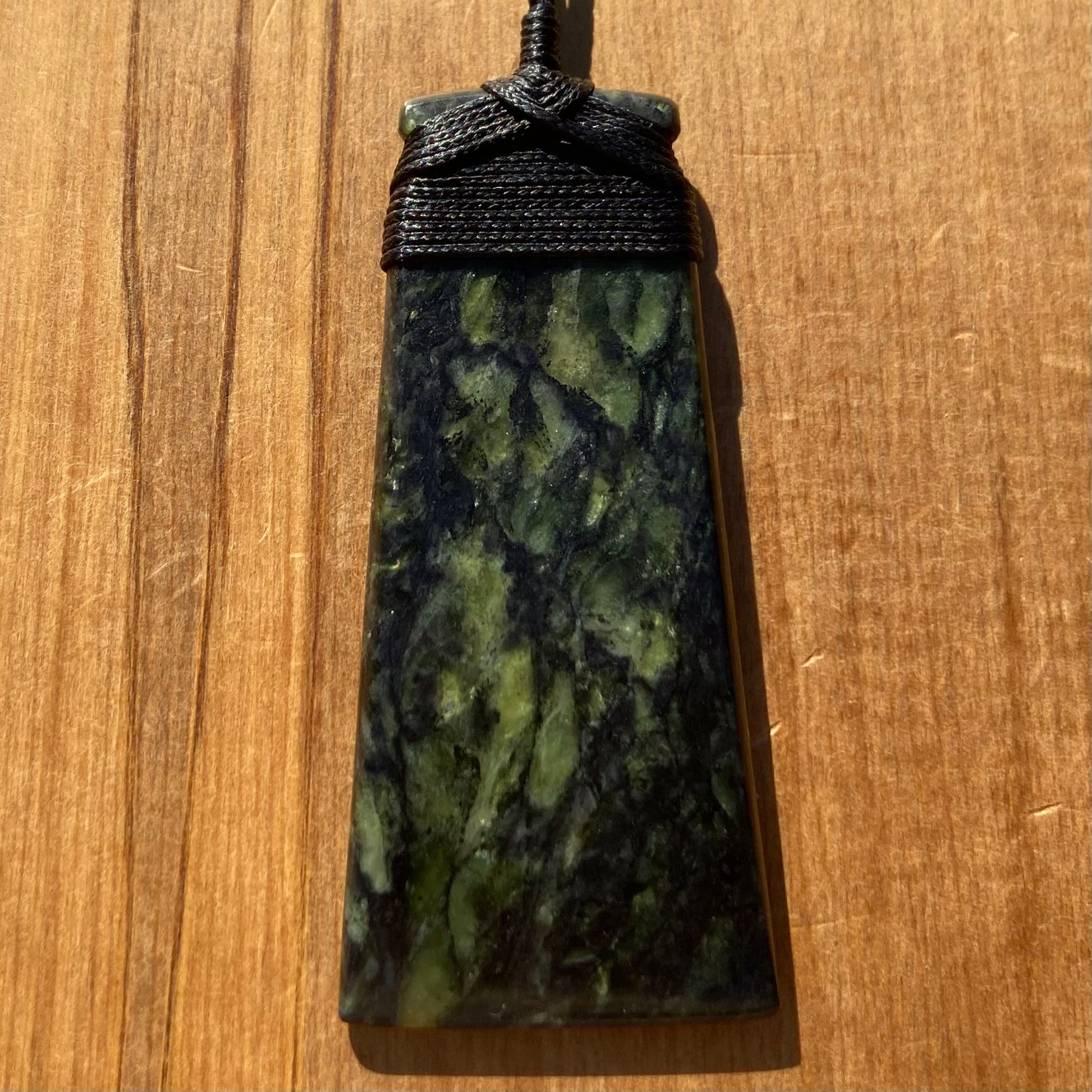 Bound toki pendant hand-carved from New Zealand Douglas Creek pounamu (greenstone). Front.