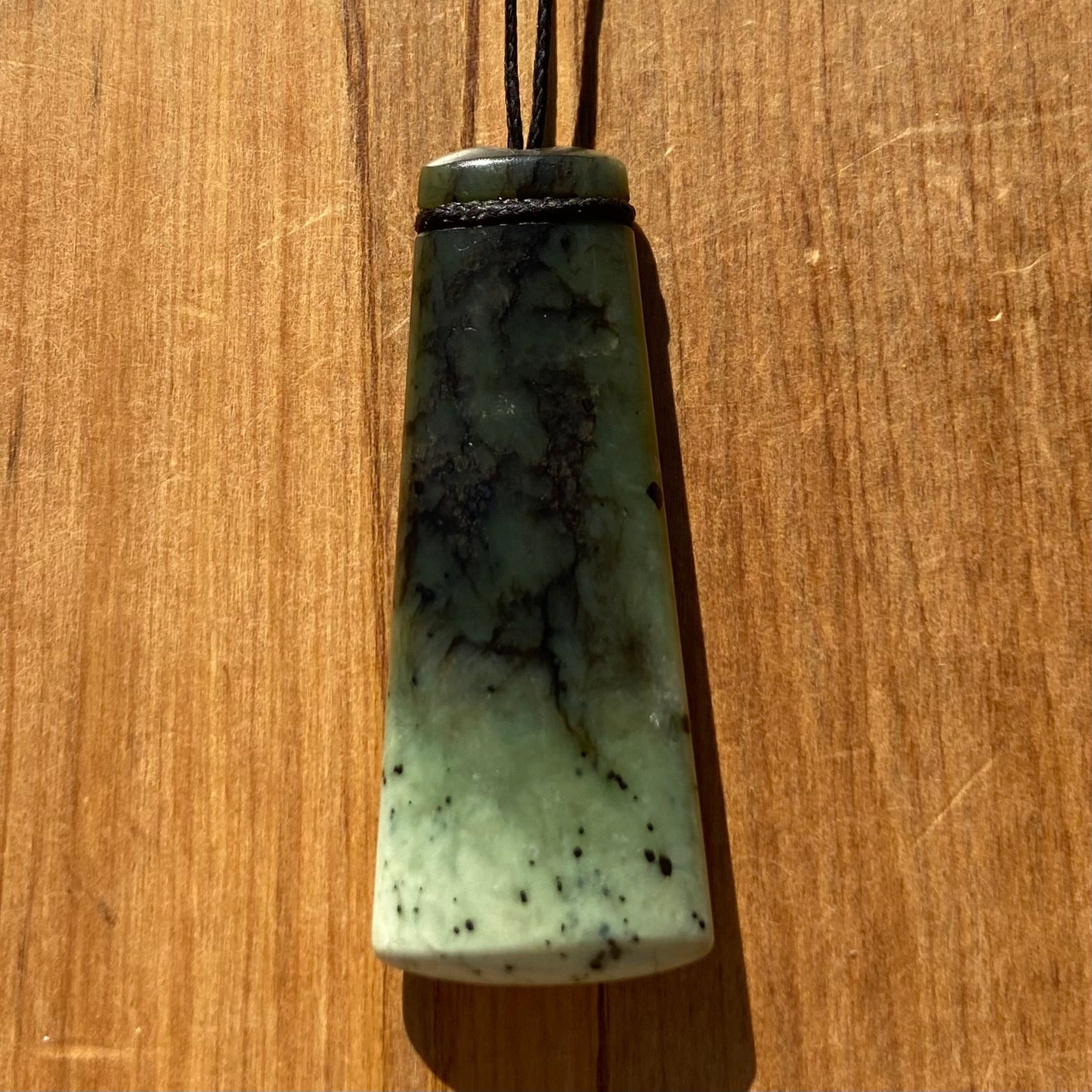 Pounamu toki pendant hand-carved from New Zealand Kawakawa pounamu (greenstone). Front.
