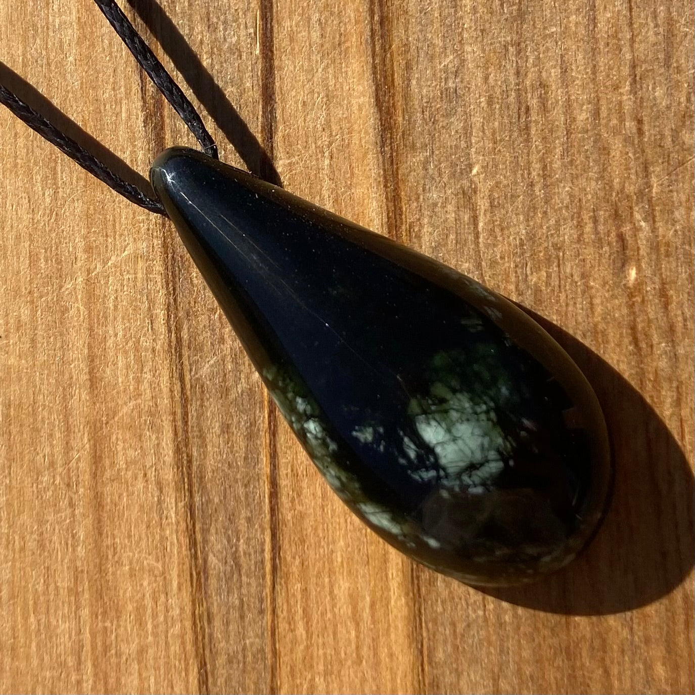 Roimata (teardrop) pendant hand-carved from New Zealand tangiwai pounamu (greenstone). Front.