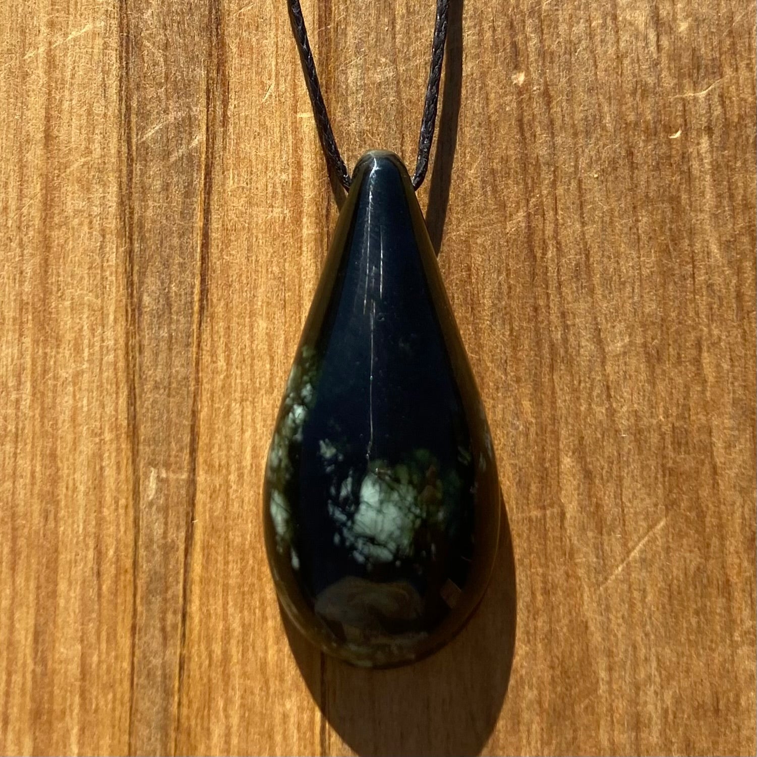 Roimata (teardrop) pendant hand-carved from New Zealand tangiwai pounamu (greenstone). Front.