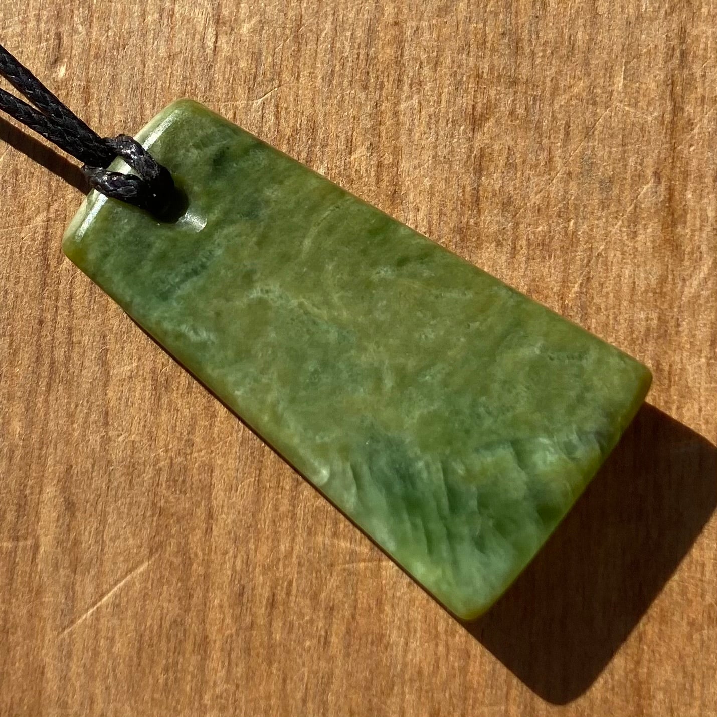 Pounamu toki pendant hand-carved from New Zealand Marsden Flower Jade pounamu (greenstone). Back.