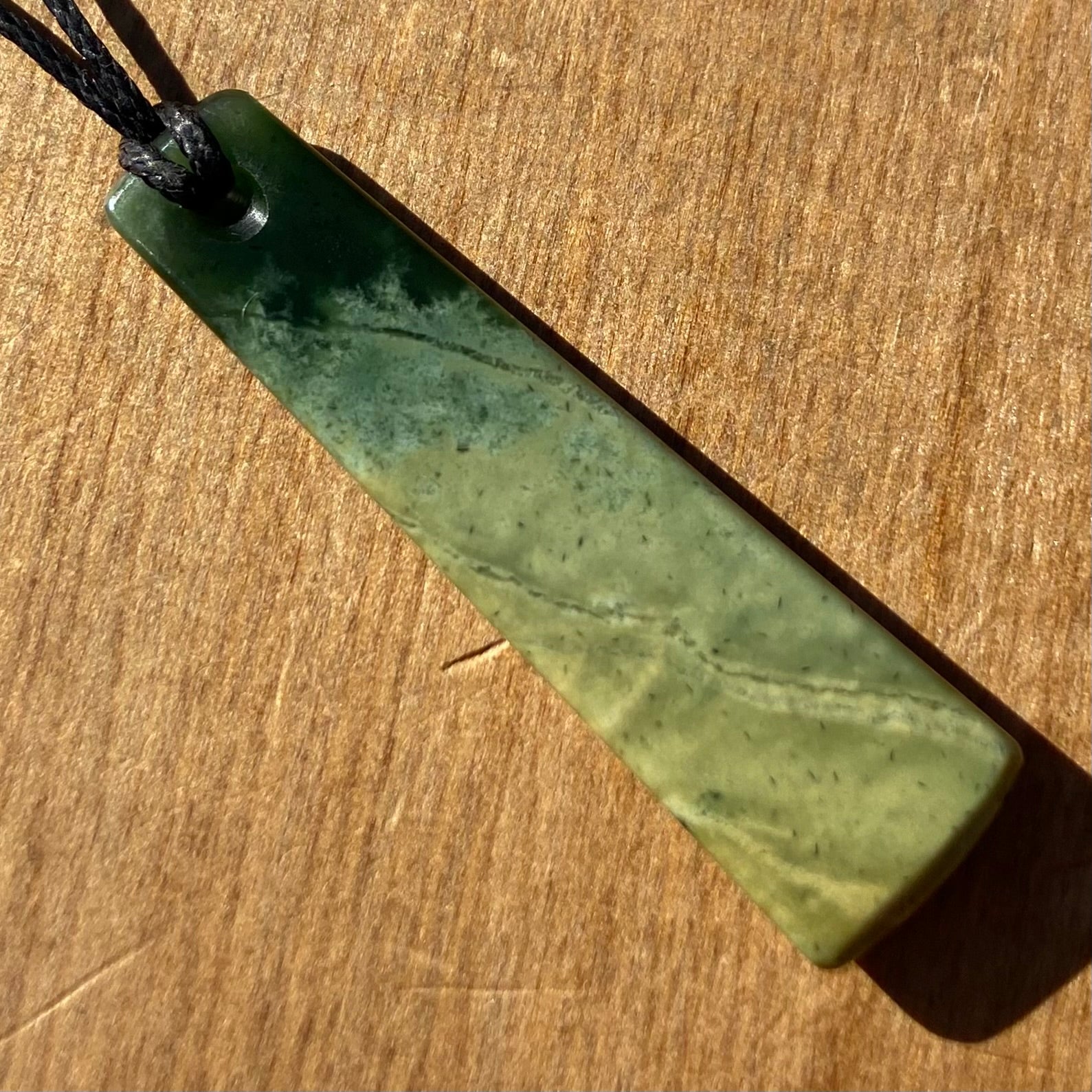 Pounamu toki pendant hand-carved from New Zealand Marsden Flower Jade pounamu (greenstone). Back.