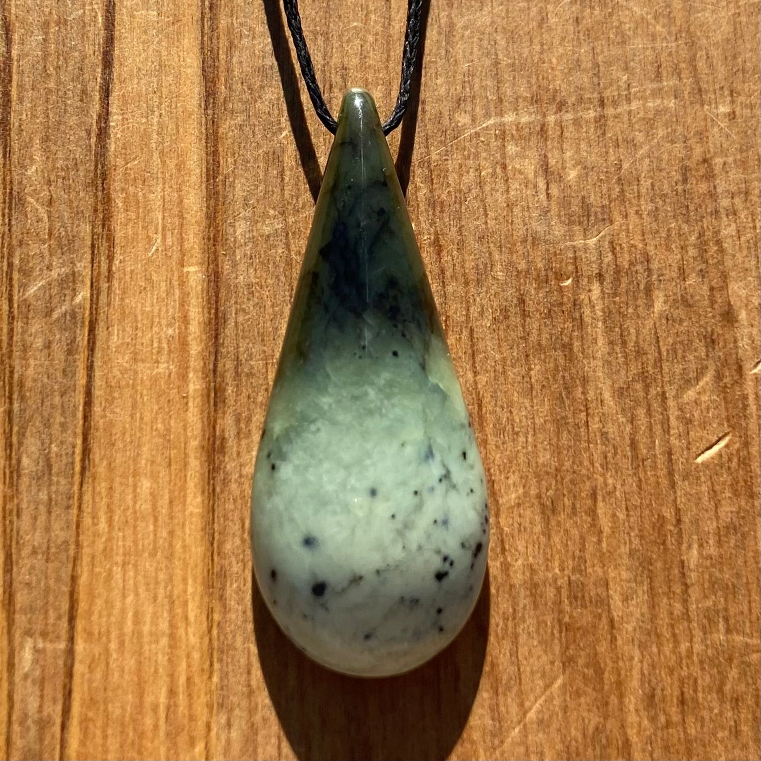 Roimata (teardrop) pendant hand-carved from New Zealand kawakawa pounamu (greenstone). Front.