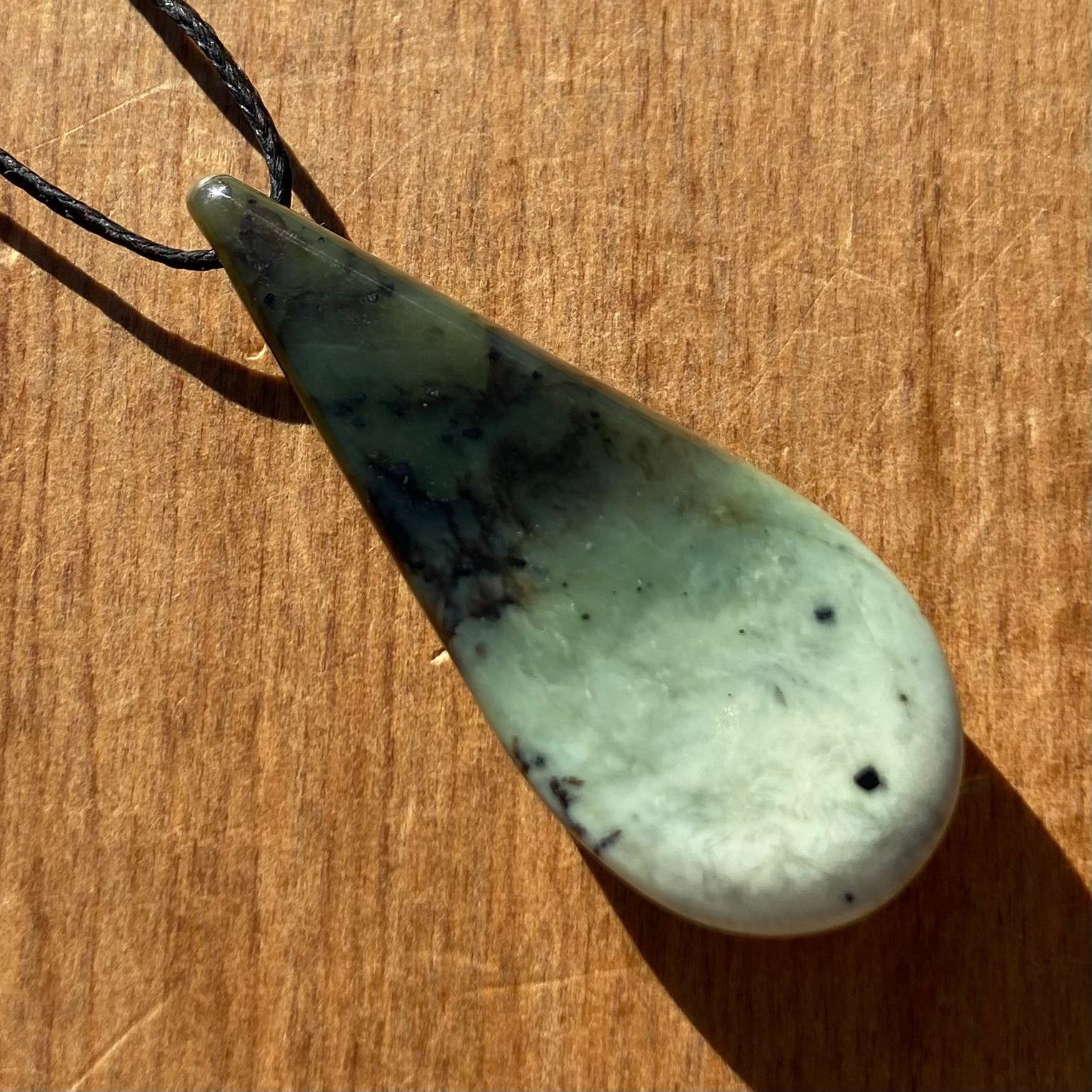 Roimata (teardrop) pendant hand-carved from New Zealand kawakawa pounamu (greenstone). Back.