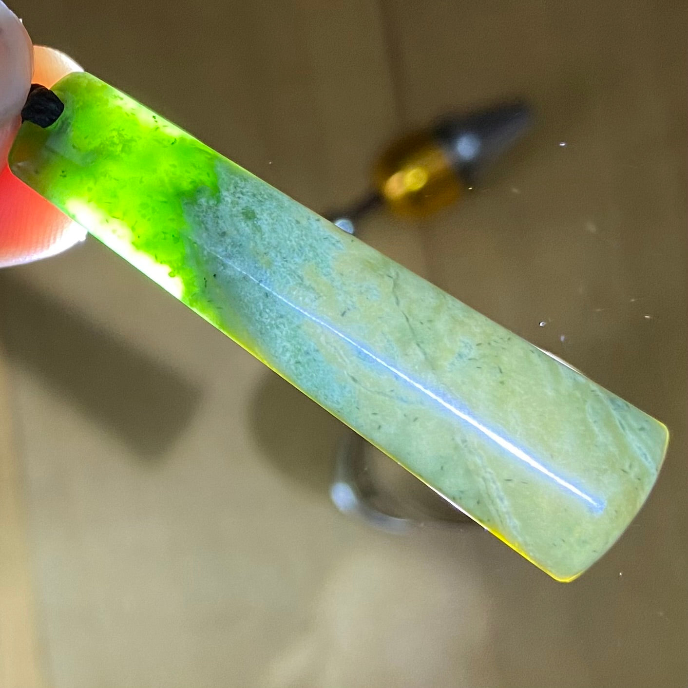 Pounamu toki pendant hand-carved from New Zealand Marsden Flower Jade pounamu (greenstone). Translucency. 