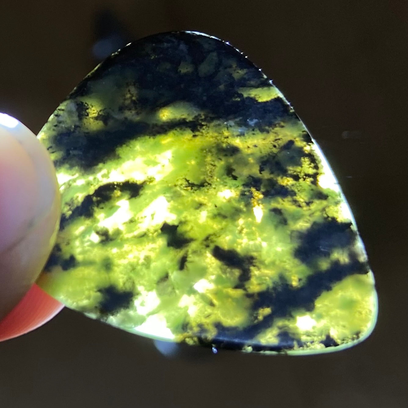 Guitar pick hand-carved from New Zealand Douglas Creek pounamu (greenstone). Translucency.