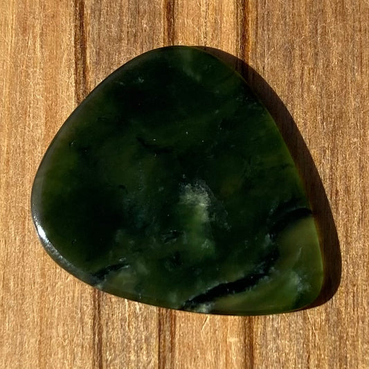 Guitar pick hand-carved from New Zealand Kawakawa Greenstone pounamu (greenstone). Front.