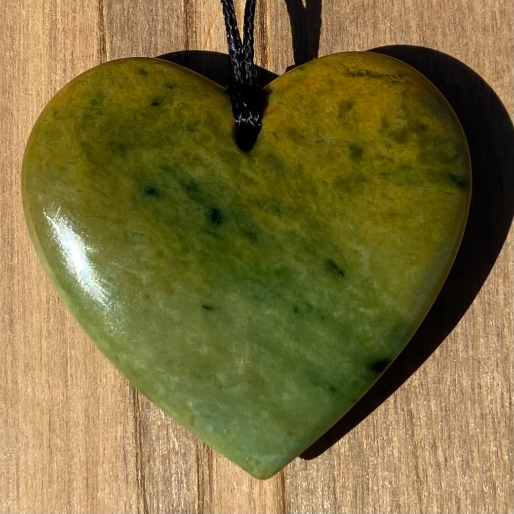 Heart shape pendant carved from New Zealand Marsden Flower Jade (greenstone). Back.