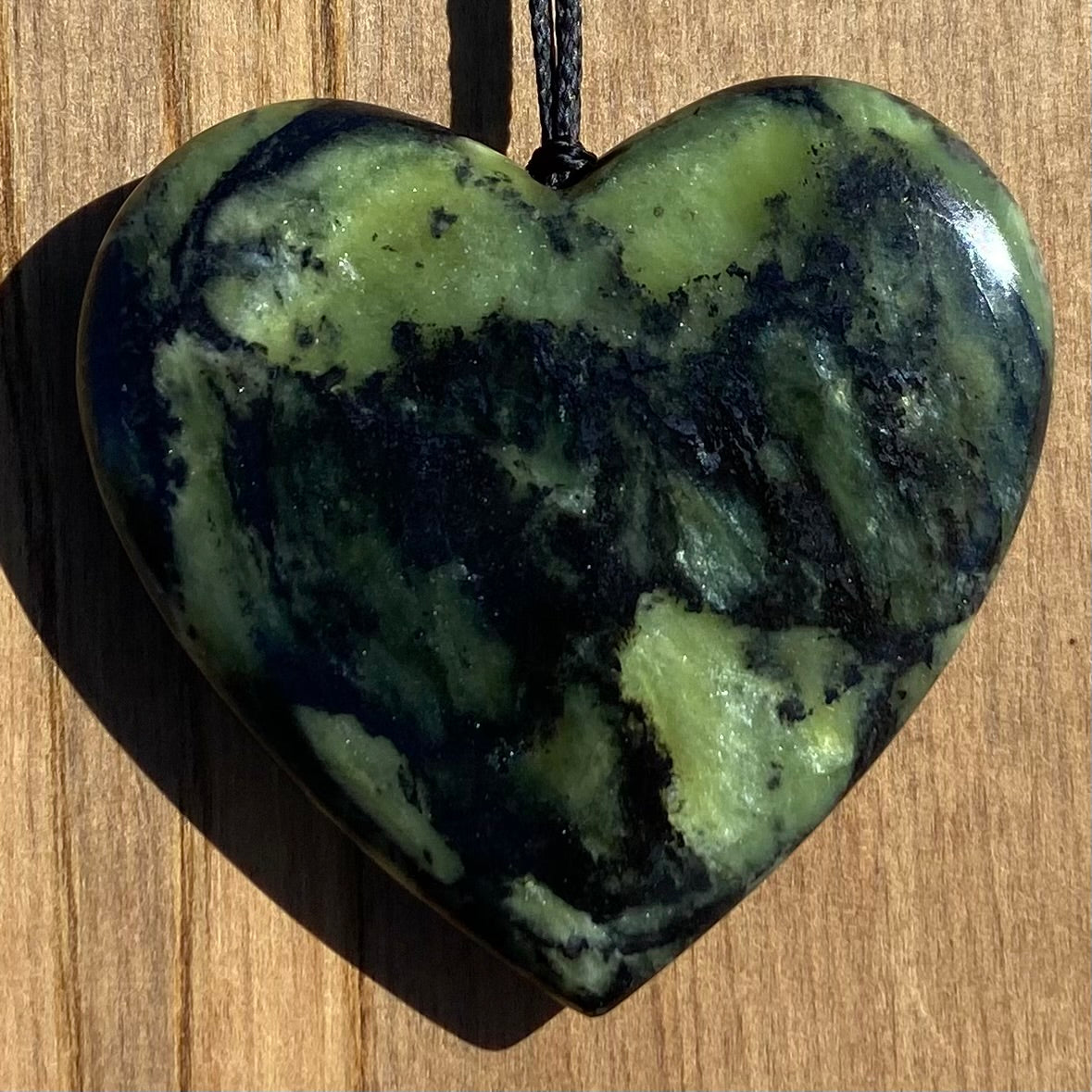 Heart shape pendant carved from New Zealand Douglas Creek pounamu (greenstone). Front.