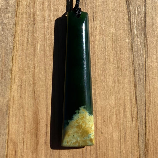 Bound toki pendant hand-carved from New Zealand Marsden Flower Jade pounamu (greenstone). Front.