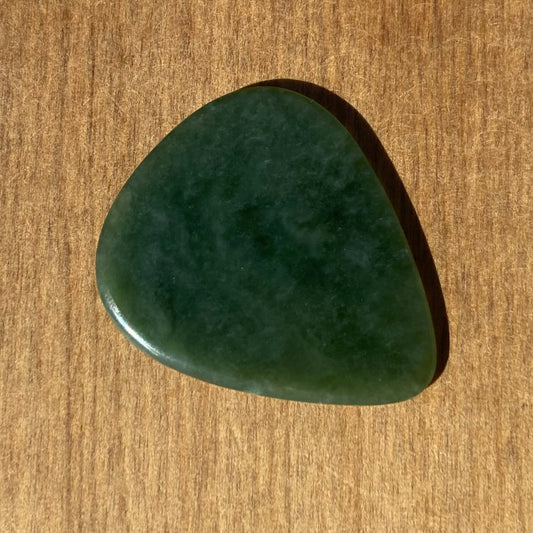 Guitar pick hand-carved from New Zealand Kahurangi Greenstone pounamu (greenstone). Front.