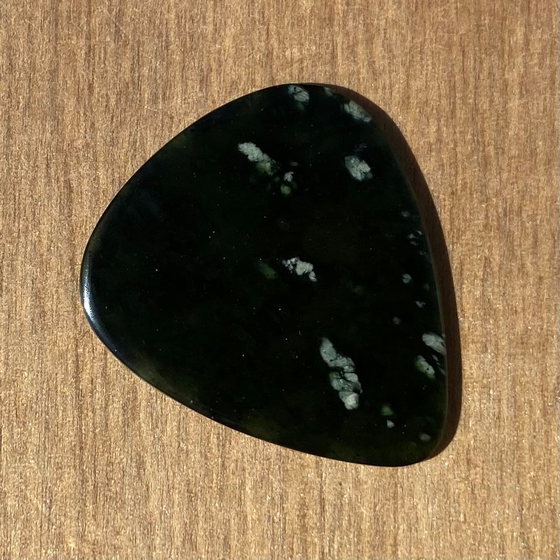 Guitar pick hand-carved from New Zealand tangiwai pounamu (greenstone). Front.