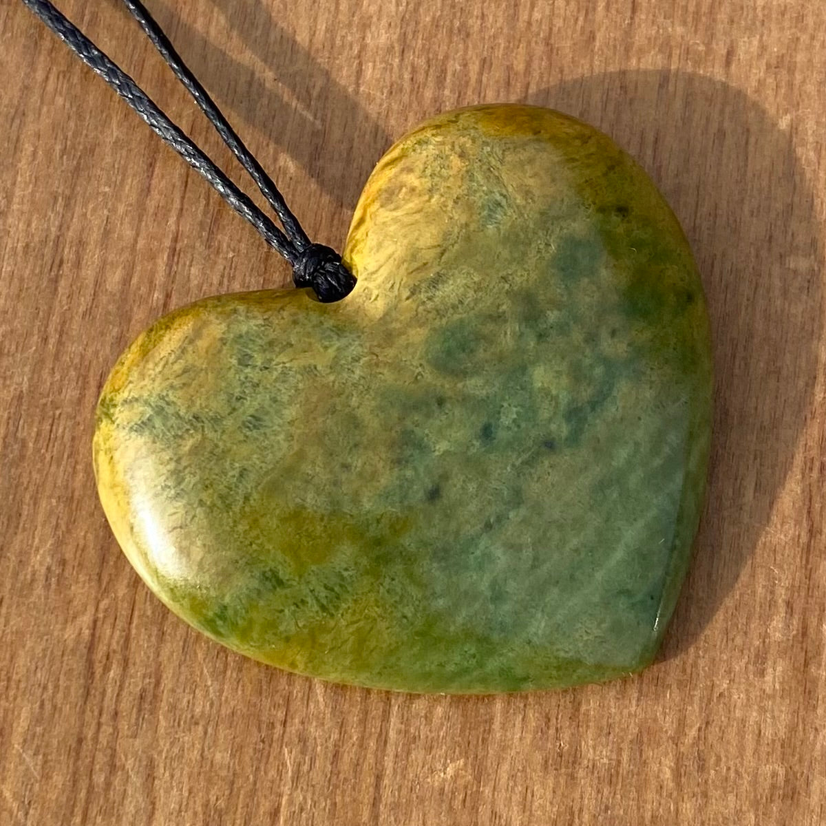 Heart shape pendant carved from New Zealand Marsden Flower Jade (greenstone). Front.