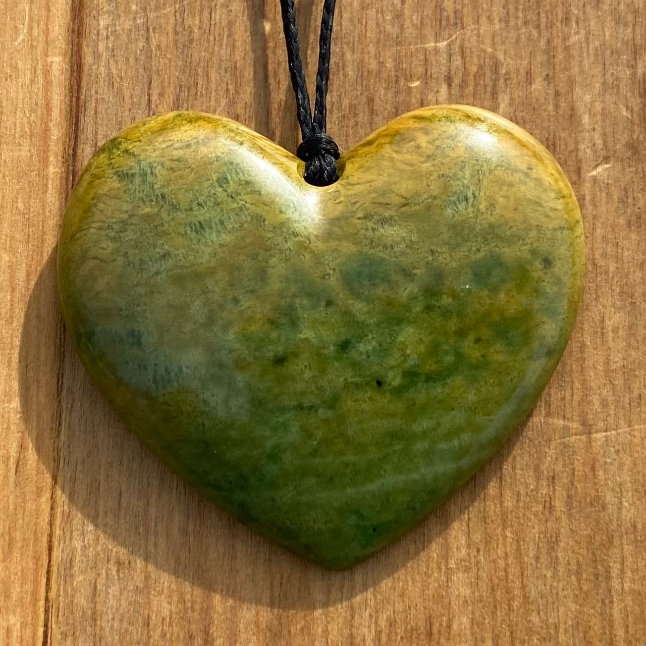 Heart shape pendant carved from New Zealand Marsden Flower Jade (greenstone). Front.