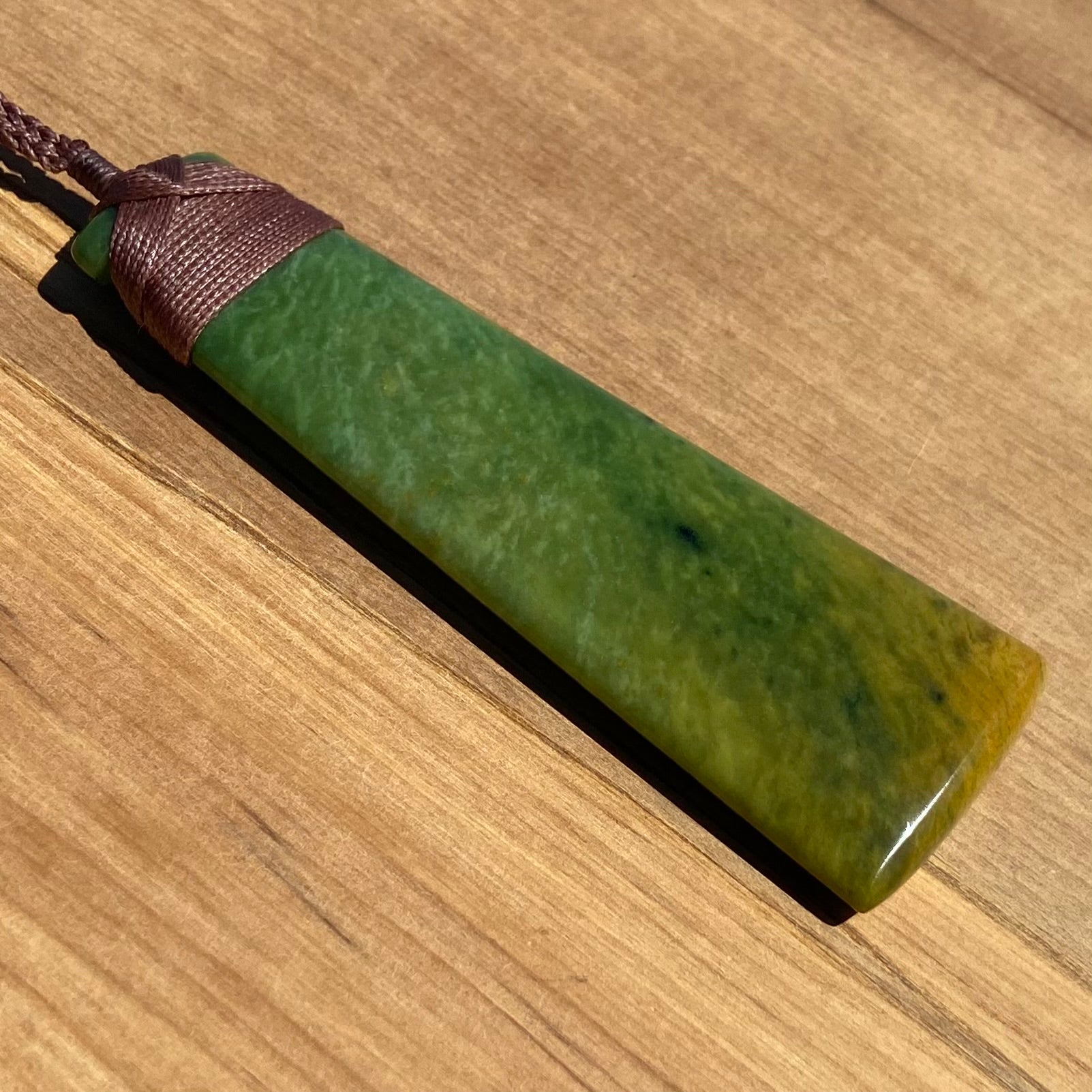 Toki pendant hand-carved from New Zealand Marsden Flower Jade/ pounamu (greenstone). Angle