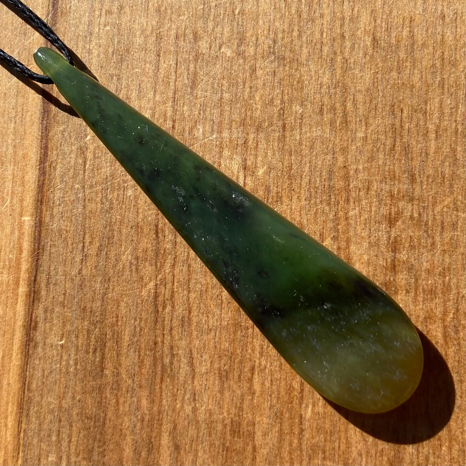 Roimata pendant hand-carved from New Zealand kawawkawa pounamu (greenstone). Back.