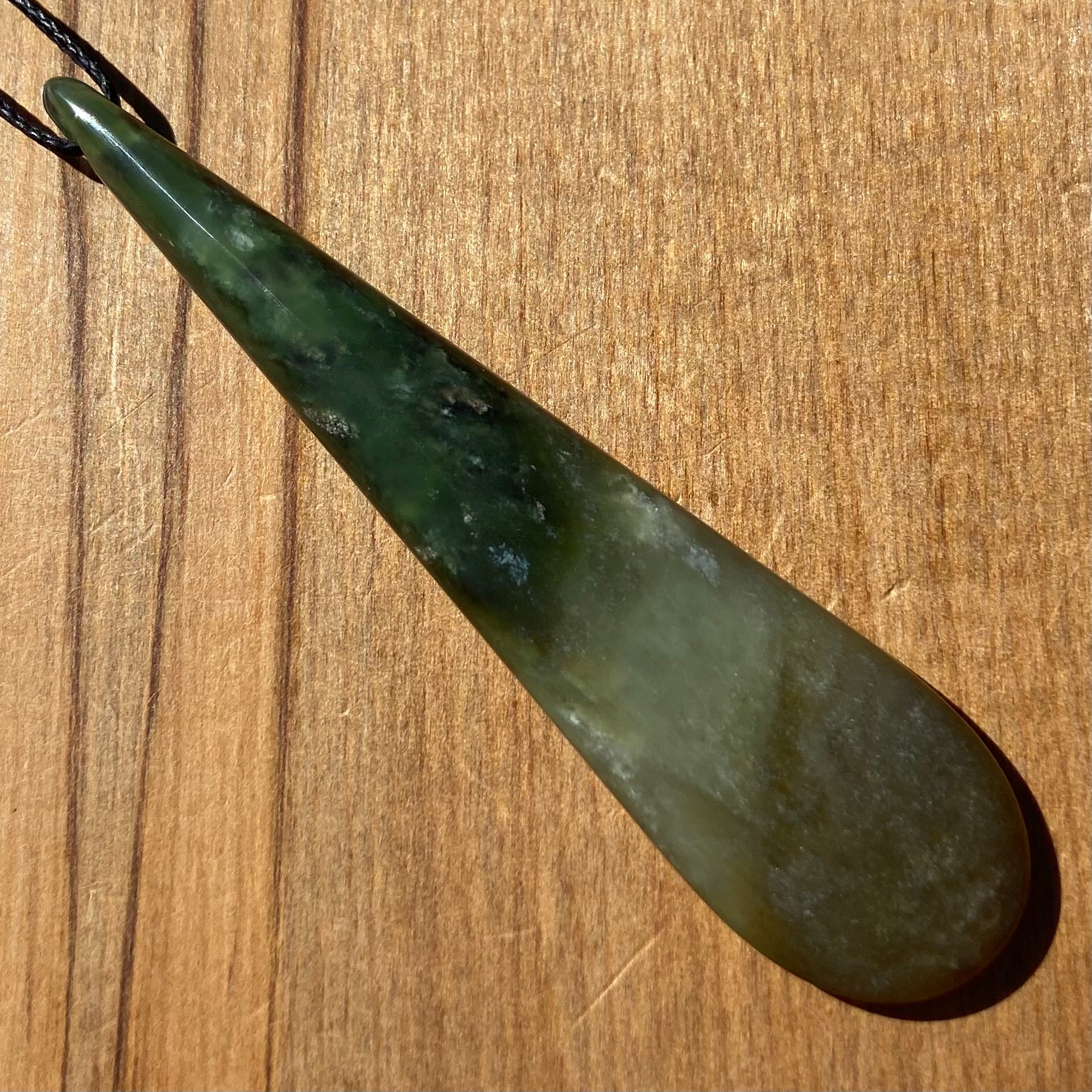 Roimata teardrop pendant hand-carved from New Zealand kawawkawa pounamu (greenstone). Front.