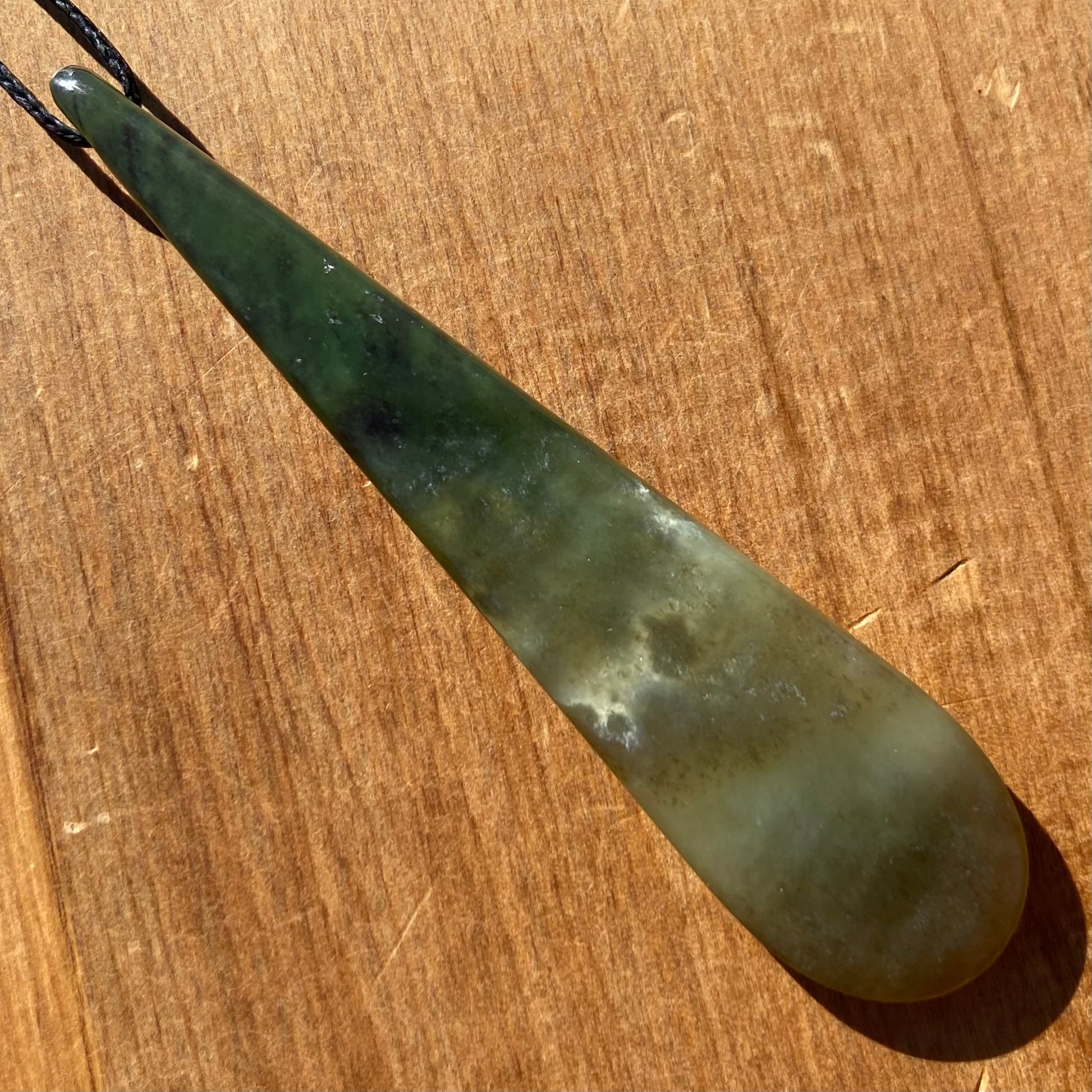 Roimata teardrop pendant hand-carved from New Zealand kawawkawa pounamu (greenstone). Back.
