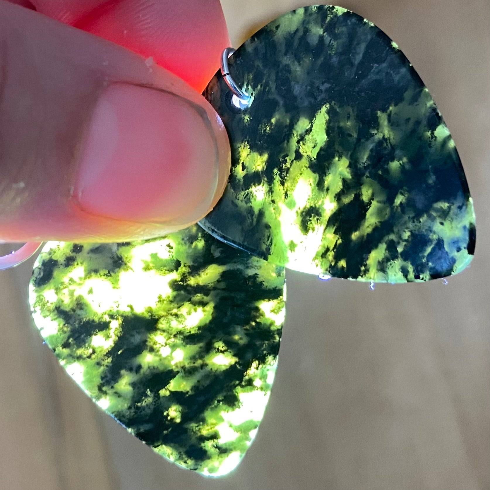 Guitar pick earrings hand-carved from New Zealand Douglas Creek pounamu (greenstone) fitted with sterling silver. Translucency