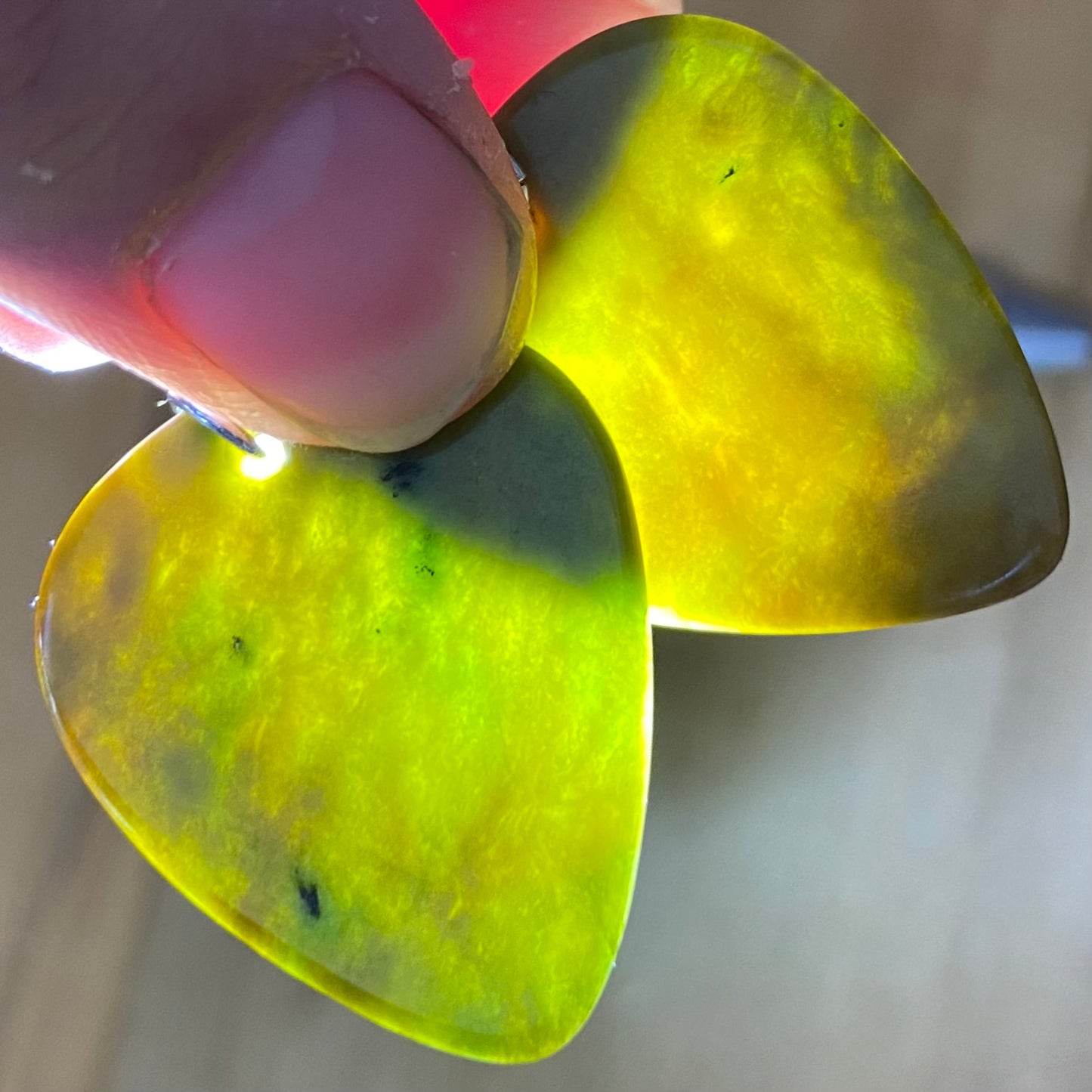Guitar pick earrings hand-carved from New Zealand Marsden Flower Jade pounamu (greenstone) fitted with sterling silver. Translucency.