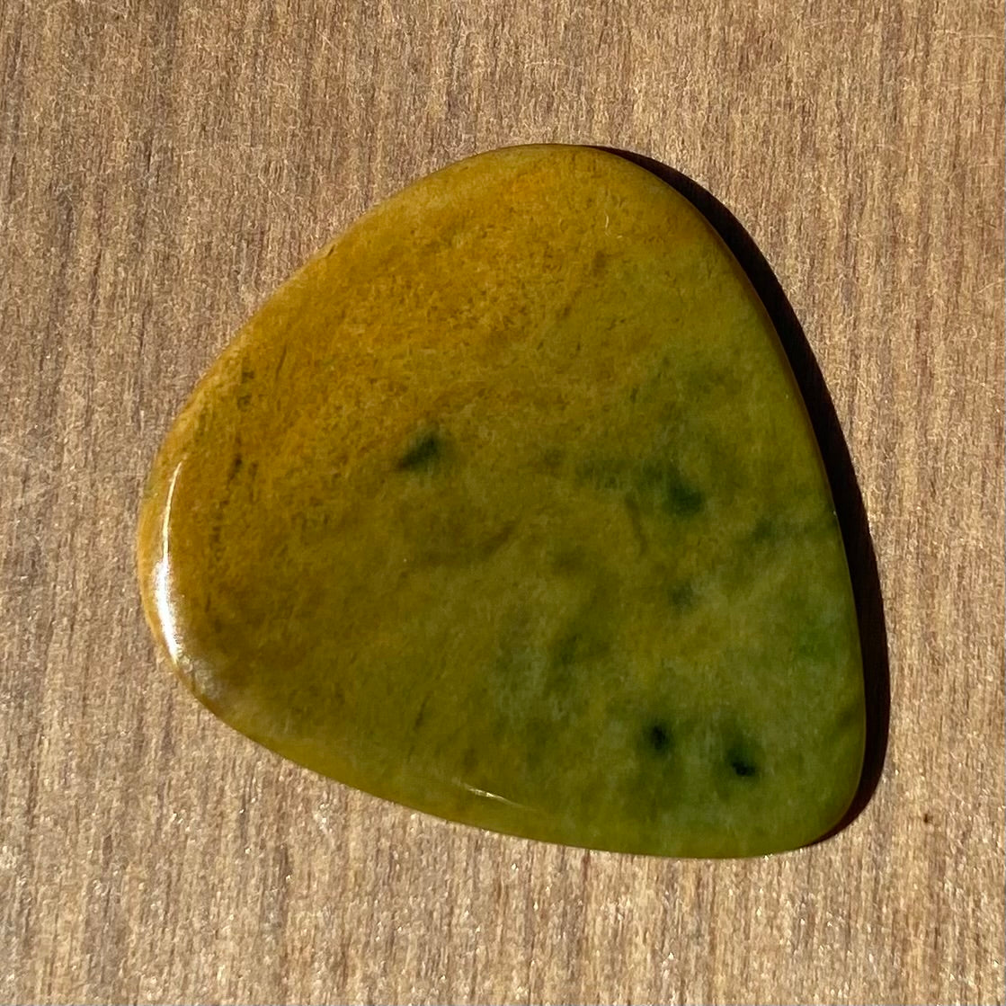 Guitar pick hand-carved from New Zealand Marsden flower jade pounamu (greenstone). Back