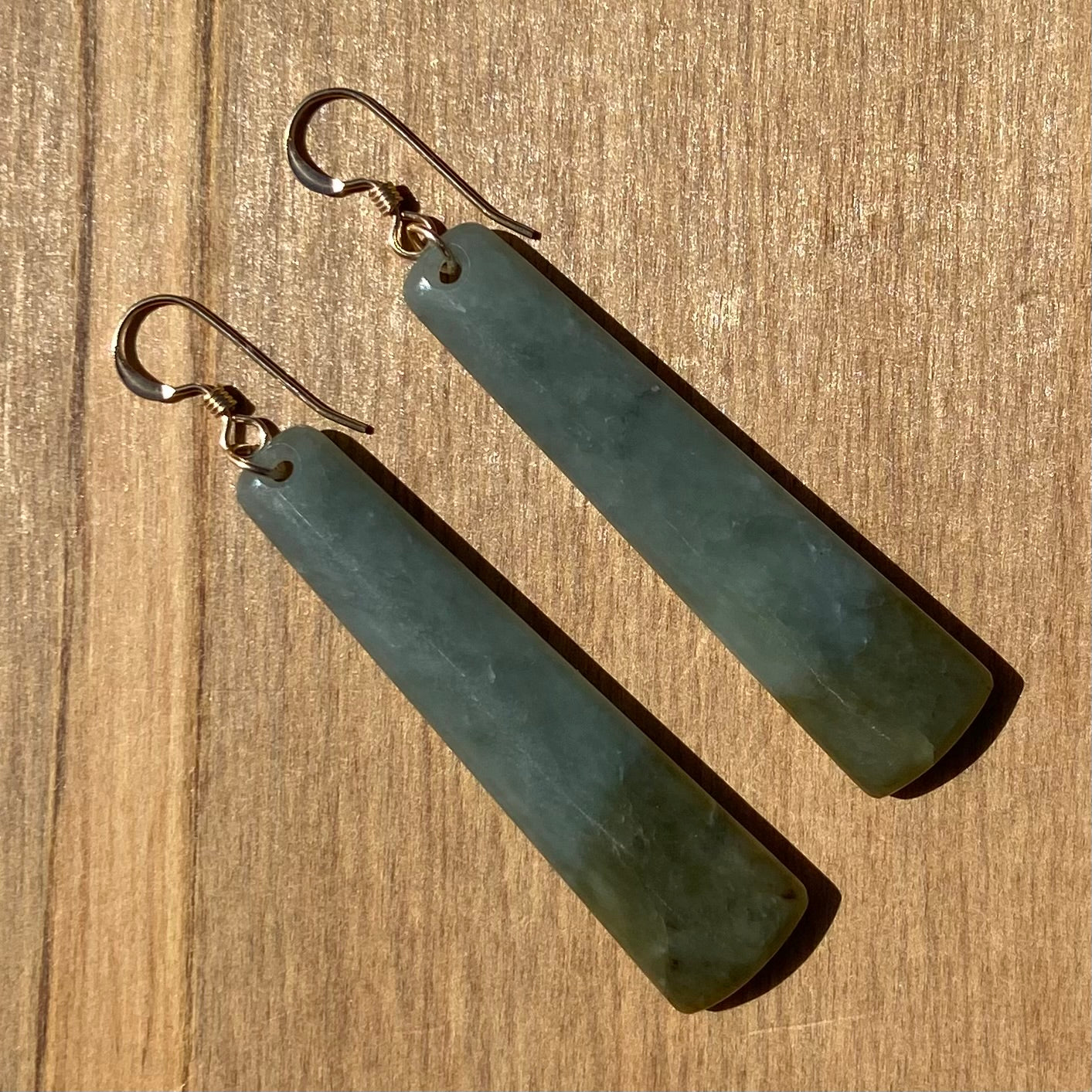 Roimata (teardrop) earrings hand-carved from New Zealand inanga pounamu (greenstone), with sterling silver fittings. Back.