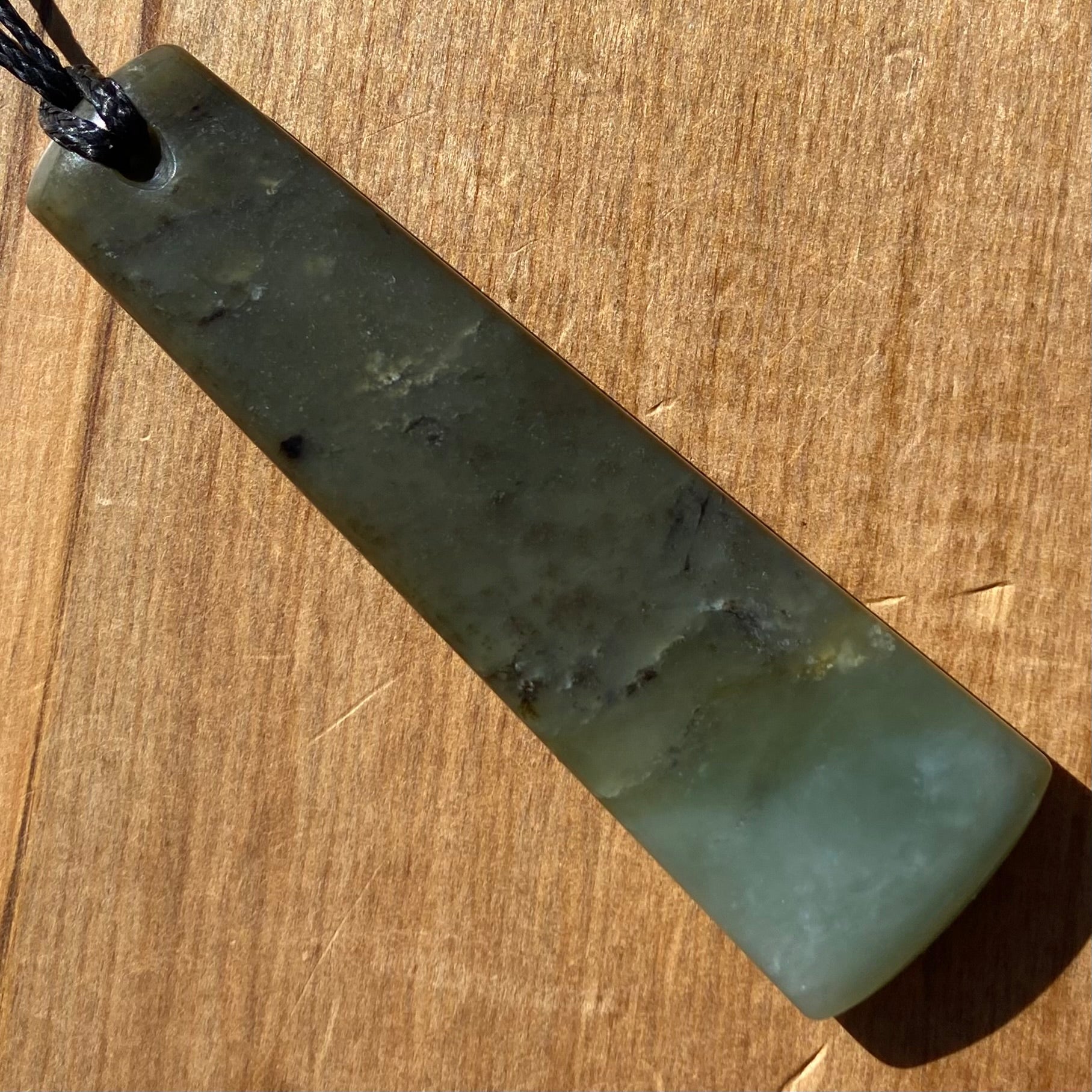 Toki pendant hand-carved from New Zealand inanga pounamu (greenstone). Back.