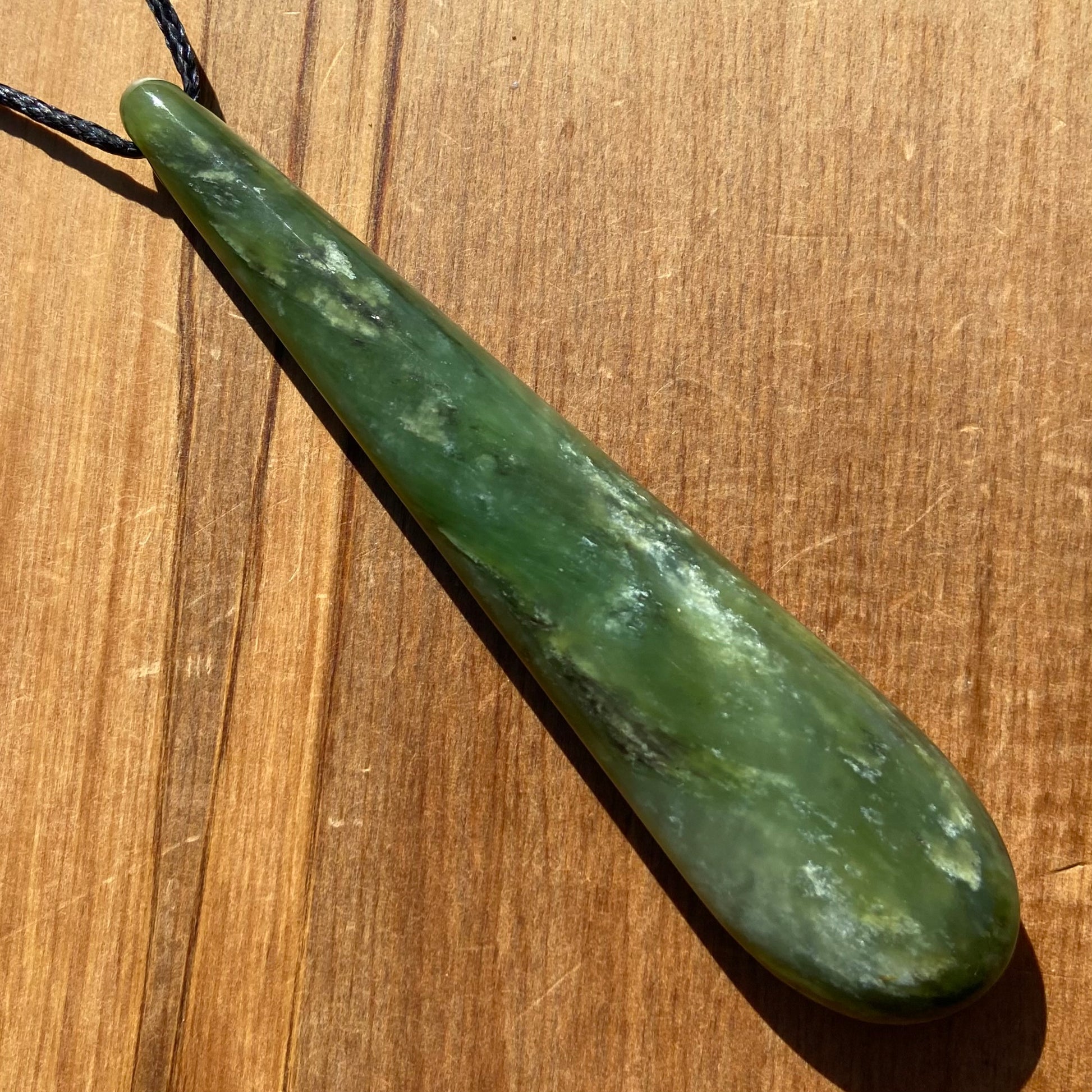Roimata teardrop pendant hand-carved from New Zealand kawawkawa pounamu (greenstone). Front.