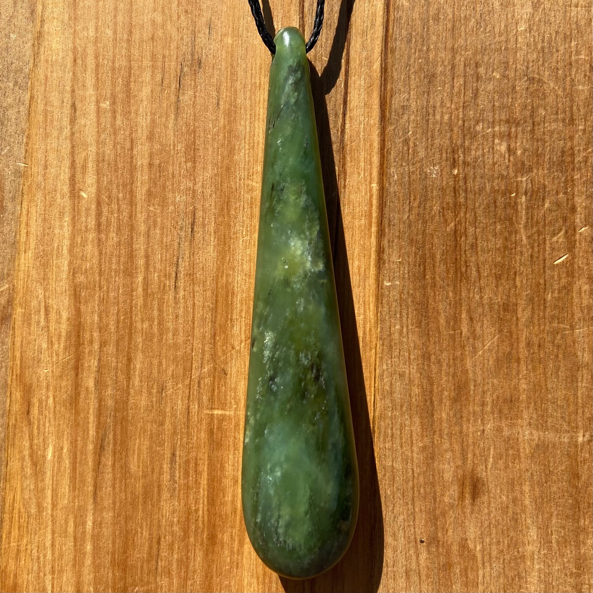 Roimata teardrop pendant hand-carved from New Zealand kawawkawa pounamu (greenstone). Front.
