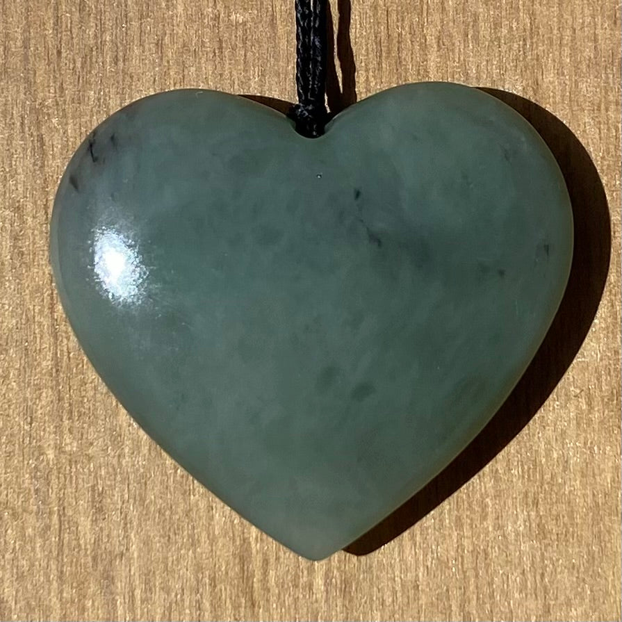 Heart shaped pendant hand-carved from New Zealand inanga pounamu (greenstone). Front.