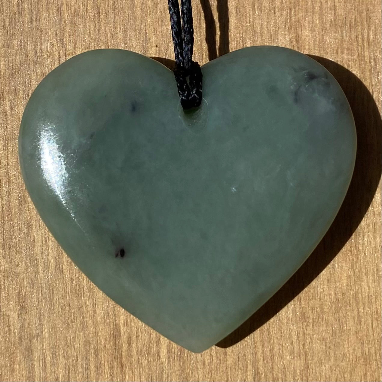 Heart shaped pendant hand-carved from New Zealand inanga pounamu (greenstone). Back.