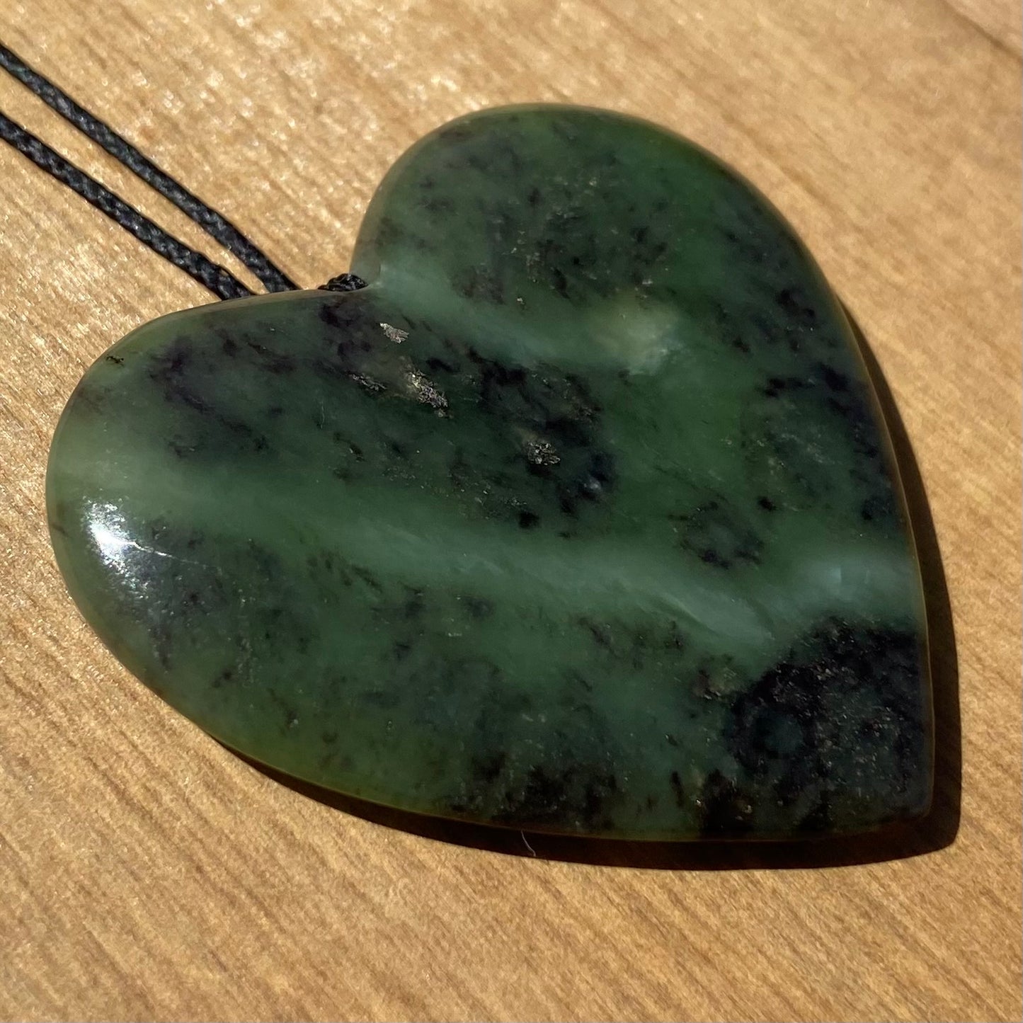 Heart pendant hand-carved from New Zealand totoweka pounamu (greenstone). Front.