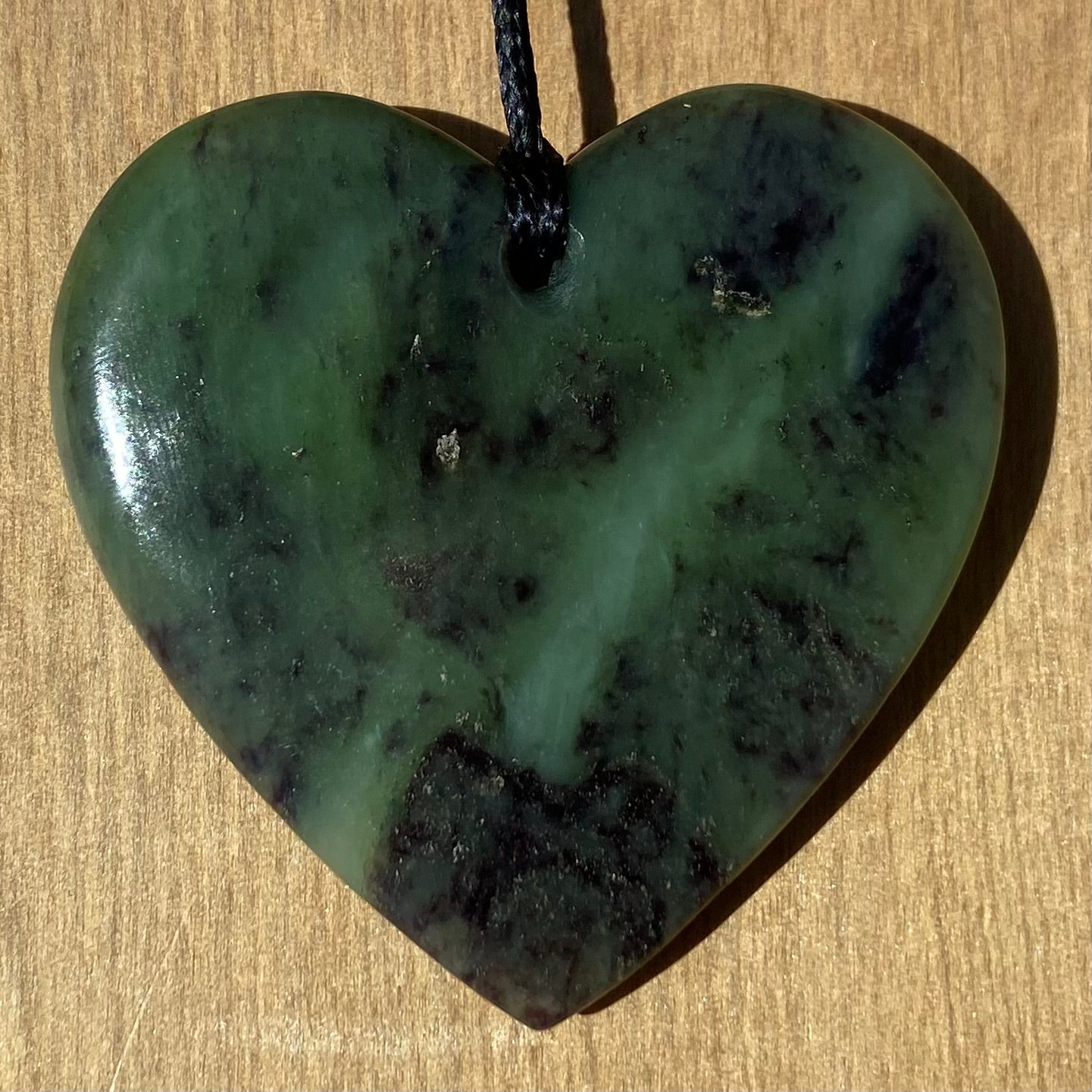 Heart pendant hand-carved from New Zealand totoweka pounamu (greenstone). Back.