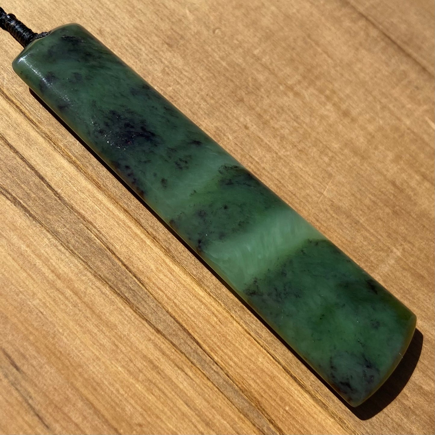 Toki pendant hand-carved from New Zealand totoweka pounamu (greenstone). Angle.