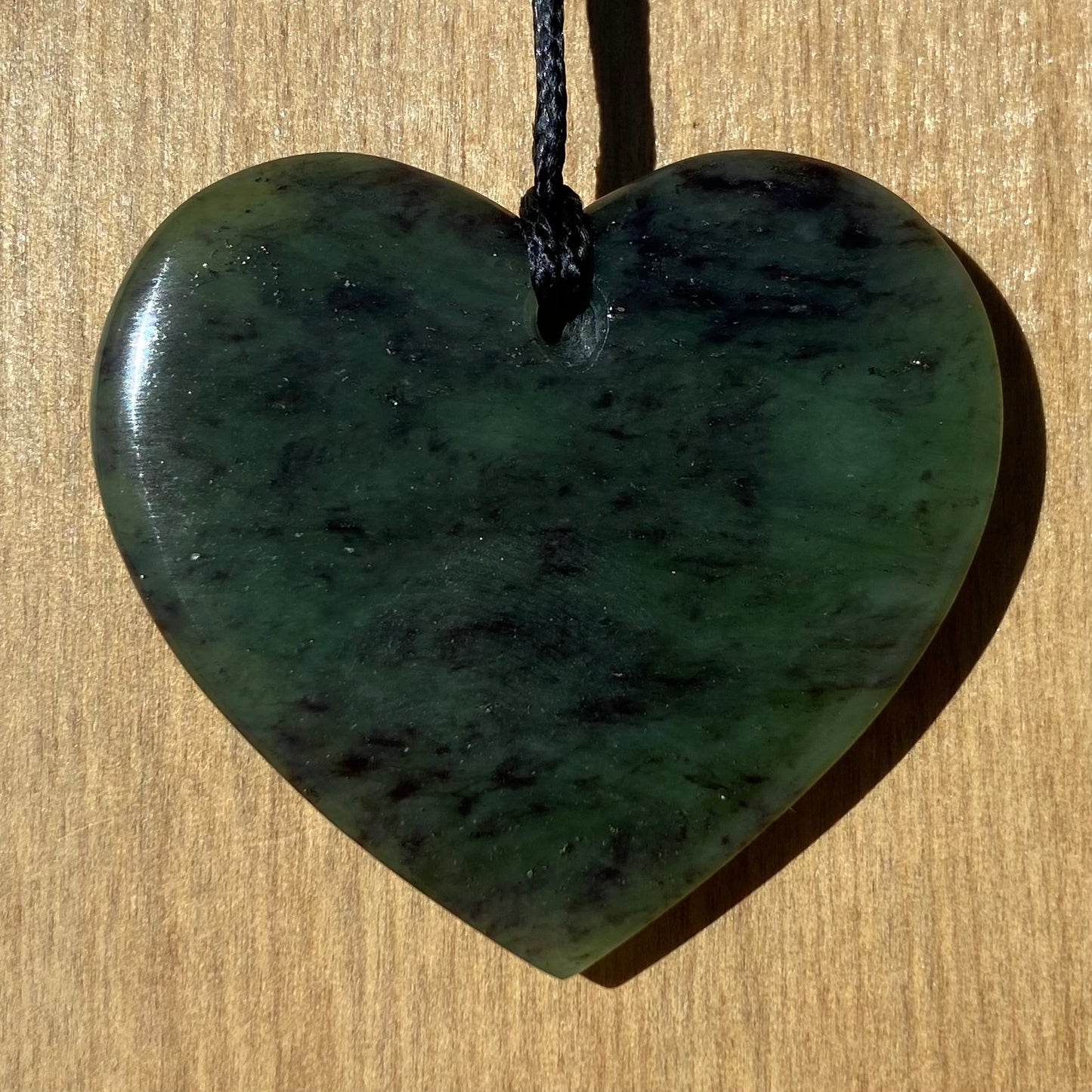 Heart pendant hand-carved from New Zealand totoweka pounamu (greenstone). Back.