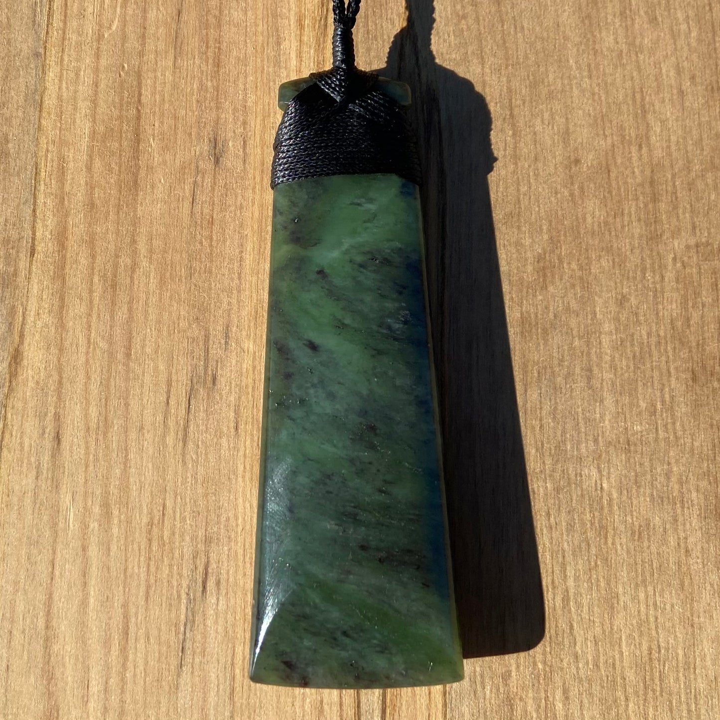 Bound toki pendant hand-carved from New Zealand totoweka pounamu (greenstone). Back.